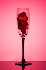 Red rose petals in a wine glass.Greeting card for Valentine's Day and birthday