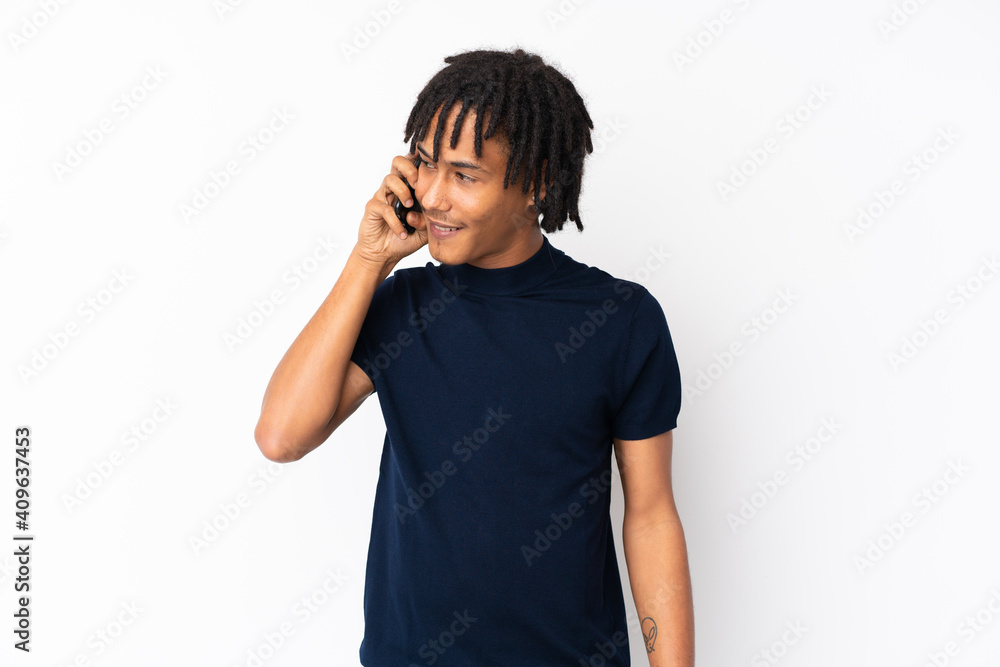 Sticker Young african american man isolated on white background keeping a conversation with the mobile phone with someone