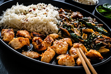 Chicken nuggets with white rice and oyster mushrooms  on wooden table