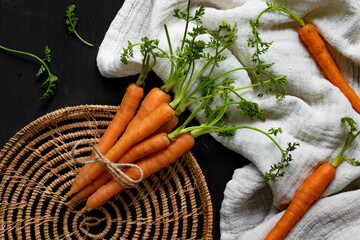 Fresh carrots on a black wooden background. Top view.