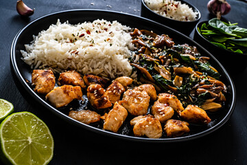 Chicken nuggets with white rice and oyster mushrooms  on wooden table