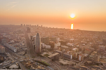 Aerial drone shot of agbar tower by Barcelona beach with sunrise