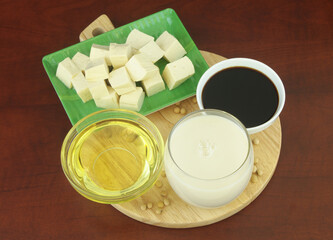 Different soy products - milk, sauce, oil and tofu on cutting board