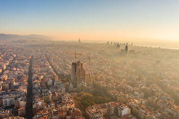 Aerial drone shot of sunrise over Barcelona city center in early morning