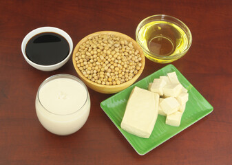 Soy beans and soy products - milk, sauce, oil and tofu on wooden table