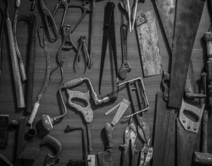 Old carpentry tools on an old workbench in black and white