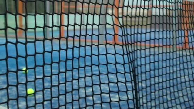 Slow motion through grid view of paddle tennis man playing on blue court outdoors. One caucasian padle player sportman hitting the ball. Racquet sport game Concept.-Dan