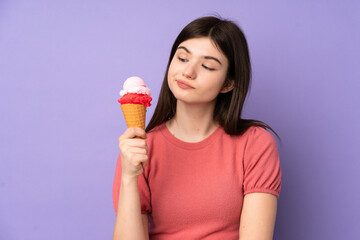 Young Ukrainian teenager girl holding a cornet ice cream over isolated purple background