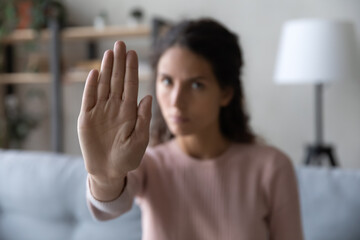 Close up serious confident strong caucasian woman showing stop gesture with hand, protesting about...