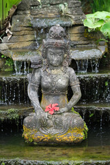 Indonesia Bali - Ubud Handmade Balinese stone statue with Hibiscus flower vertical