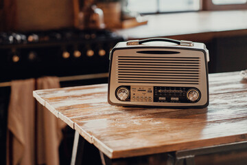 an old vintage radio receiver sits on a wooden table. stylish old kitchen morning in the village...