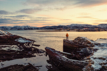 Graveyard of ships, winter sunset view in an old fishing village on the shore of the Barents sea, the Kola Peninsula, Teriberka