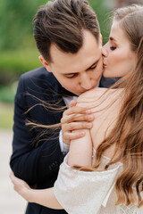 beautiful, gentle and happy bride and groom. man gently kisses woman's shoulder