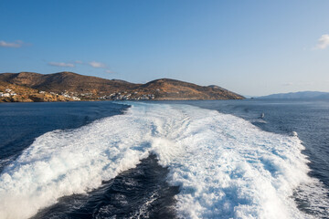 Fototapeta na wymiar Water trail foaming behind a ferry boat in Aegean Sea near Ios island. Cyclades, Greece.