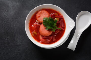 Hot red beet Kubbeh soup, a famous middle eastern dumplings soup dish, served in a bowl. A Jewish-Iraqi traditional matfuniya winter soup. Levantine dish made of bulgur, minced onions, ground  beef