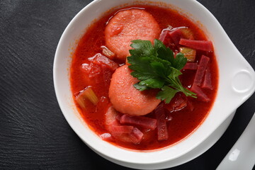 Hot red beet Kubbeh soup, a famous middle eastern dumplings soup dish, served in a bowl. A Jewish-Iraqi traditional matfuniya winter soup. Levantine dish made of bulgur, minced onions, ground  beef