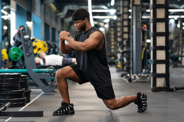Fototapeta na wymiar Black guy sportsman doing squats in gym