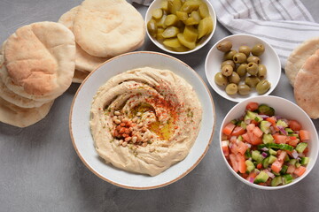 Classic hummus with olive oil on the plate and pita bread.