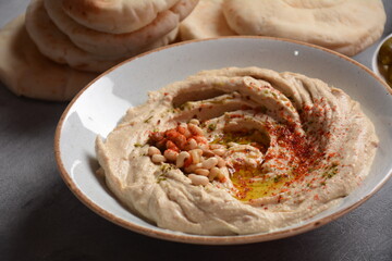 Classic hummus with olive oil on the plate and pita bread.