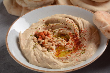 Classic hummus with olive oil on the plate and pita bread.