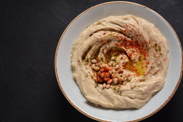 Classic hummus with olive oil on the plate and pita bread.