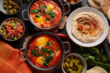 Shakshouka, eggs poached in sauce of tomatoes, olive oil, peppers, onion and garlic, Mediterranean...
