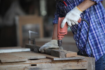 Carpenter, joiner is working in the workshop. Man at work on wood.Image of mature carpenter in the workshop,furniture making concept.