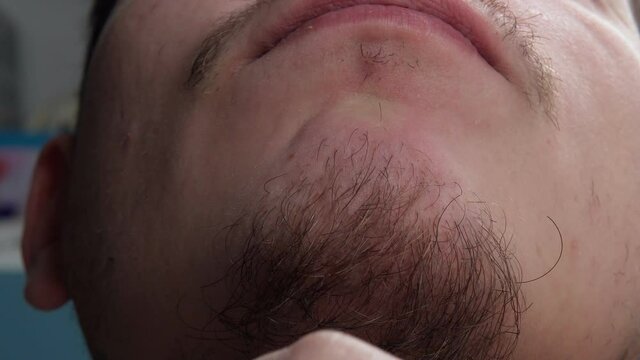 Close-up of young bearded man touching his beard. selective focus