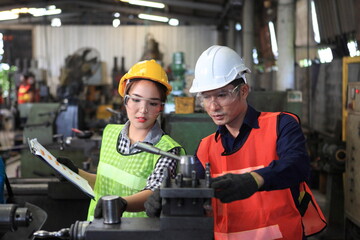 Male and Female Industrial Engineers with  machine. Assist production engineer in industry.  checking metalwork control in industrial In a plastic factory for car. Concept Successful of Work.