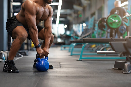 Cropped of black muscular man working out with kettlebell