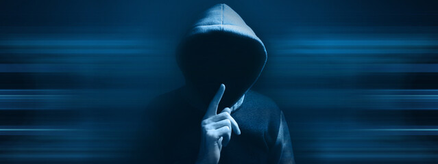 hooded man making silence gesture