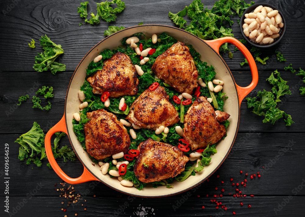 Wall mural One-pot braised chicken thighs with kale and cannellini beans served with chili peppers