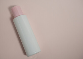 An empty white plastic bottle made of decomposing material with a pink lid on a pink background. Packaging of cream, body lotion, gel, facial foam or skin care products. 