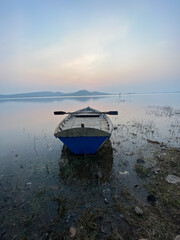 boat at sunset | old wooden fishing boat in a still river water