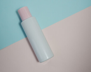 liquid makeup remover, cream, spa plastic white bottle on white and blue background.