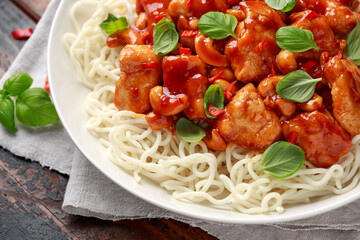 Sweet Chilli Chicken with noodles on wooden table. asian food