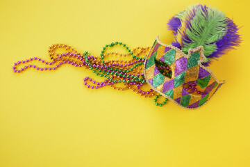 Mardi gras or carnival mask with beads on yellow background. Venetian mask. © vetre