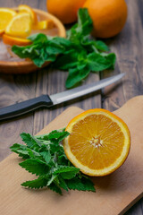 Delicious orange lemonade with soda water and mint on old wood table, space for text. Fresh summer cocktail.