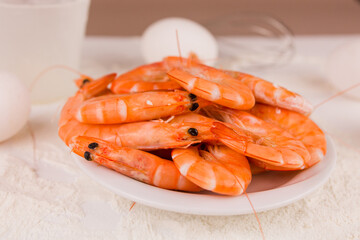 beautiful large boiled tiger prawns on a white plate on the kitchen table