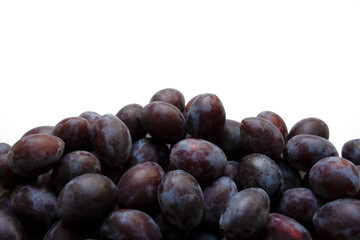 Heap of fresh ripe plums on white background close up