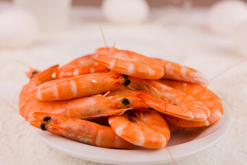 beautiful large boiled tiger prawns on a white plate on the kitchen table