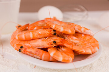beautiful large boiled tiger prawns on a white plate on the kitchen table