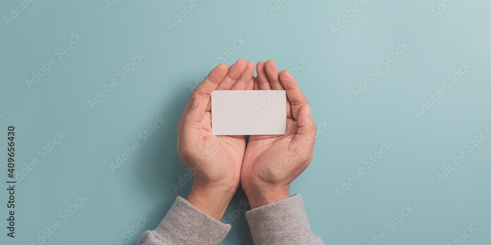 Poster hand holding blank business name card on blue background with copy space for input wording and infog