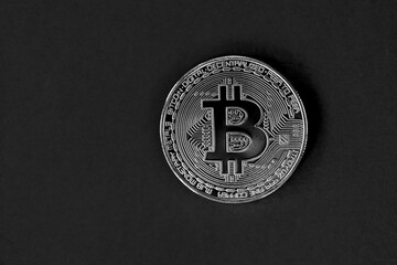 Bitcoin physical coin cutout on black background with negative space for copy