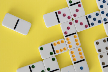 Colorful dominoes arranged on yellow background