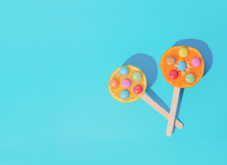 Tropical summer scene with fruit lollipops with a blue background. Minimal aesthetics. The concept of refreshment.