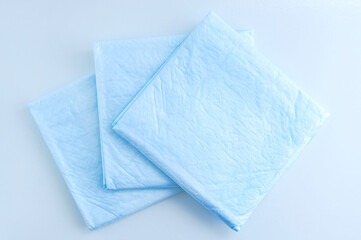 Medical blue absorbent diaper wipes on white background.