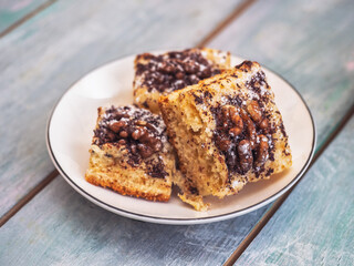 Homemade cookies with walnuts, sprinkled with chocolate and powdered sugar on a white plate
