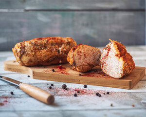 Baked chicken breast ham with spices on a cutting kitchen board close-up