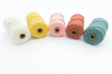 Close-up view of the colorful single strand cotton cords for macrame DIY handcraft on white background.